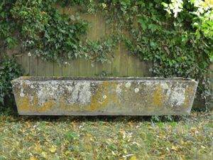 A mid 20th century composition stone trough