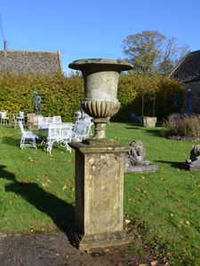 A weathered limestone campana shaped urn 