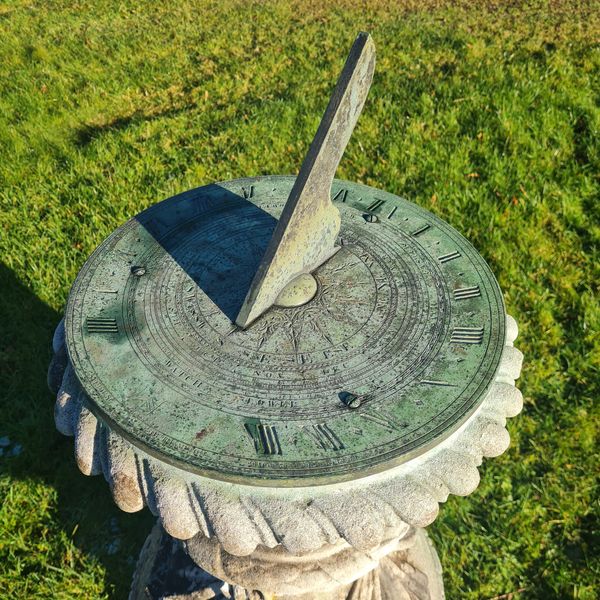 Carved Portland stone sundial with bronze dial plate