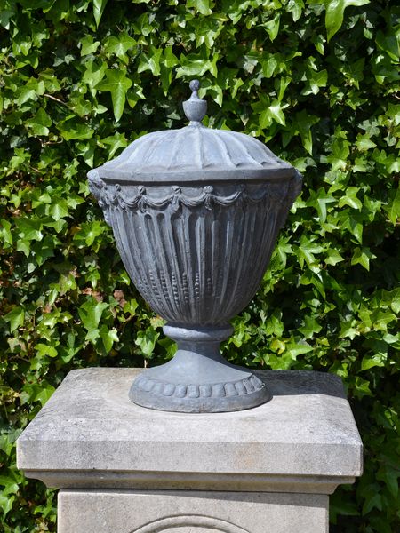 A pair of lead finial urns in the Adam style