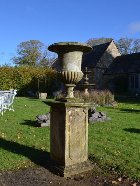 A weathered limestone campana shaped urn 
