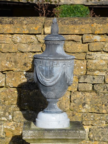 A pair of lead final urns in the manner of Robert Adam 
