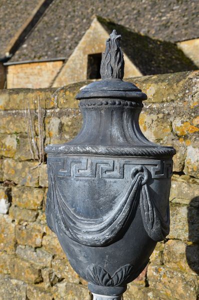 A pair of lead final urns in the manner of Robert Adam 