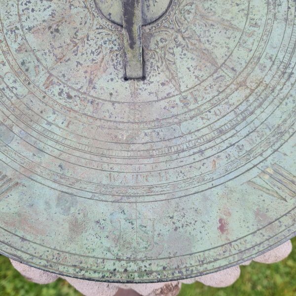 Carved Portland stone sundial with bronze dial plate