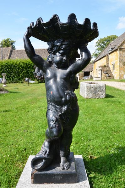 A large cast iron figure holding aloft a conch shell by the Durenne Foundry