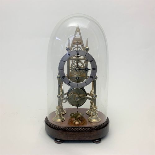 Brass skeleton clock in glass dome