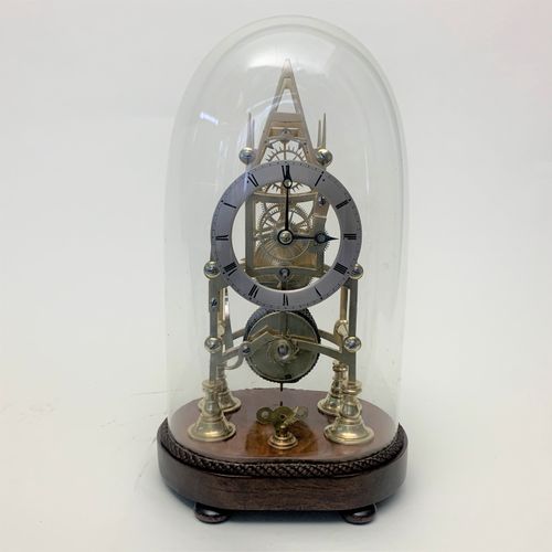 Brass skeleton clock in glass dome